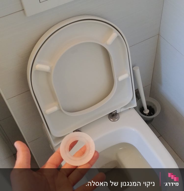 יד מחזיקה אטם גומי ליד אסלה פתוחה